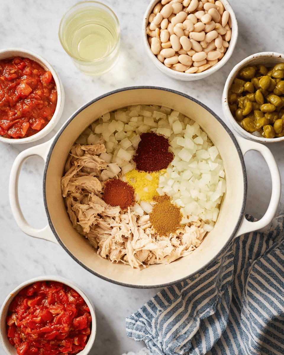 A white pot with two handles holds chopped white onions at the base, topped with three small piles of spices: one light brown, one dark reddish-brown, and a small amount of minced yellow garlic in the middle. Surrounding the pot on a white marbled surface are five white bowls, each containing different ingredients: white beans, shredded light pinkish chicken, red diced tomatoes in sauce, a reddish-brown sauce, and chopped green pickles. A nearby glass with pale yellow liquid and a striped blue and white cloth are also visible. photo taken with an iphone --ar 4:5 --v 7