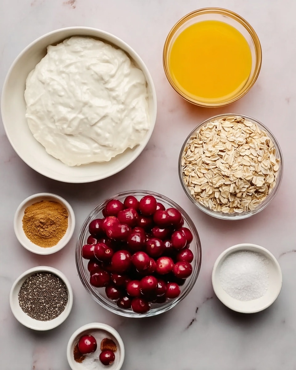 The image shows several bowls on a white marbled surface. There is a large white bowl filled with thick white yogurt or cream in the top left, next to a medium white bowl full of light beige rolled oats in the center. To the right, a clear glass bowl is filled with bright red fresh cherries. A medium clear bowl on the top right is full of smooth bright orange liquid, likely juice. Around them are small white bowls holding various powders: one with light brown powder, one with dark chia seeds, one with white granulated sugar, and a small white bowl holding both ground cinnamon and salt side by side. The setup is clean and neatly arranged, showing raw ingredients before mixing. photo taken with an iphone --ar 4:5 --v 7