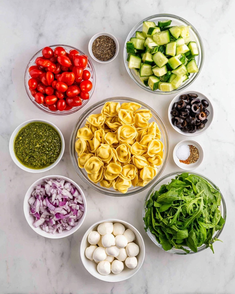 The image shows nine clear and white bowls arranged on a white marbled surface in a loose circle around a large central bowl. The large central bowl is filled with yellow tortellini pasta. At the top left is a bowl of bright red cherry tomatoes, cut in half. At the top center is a bowl with chopped green cucumbers. To the top right is a smaller bowl containing sliced black olives. Below the olives is a tiny bowl with half salt and half black pepper. To the right center is a bowl filled with fresh green arugula leaves, and at the bottom right is a bowl with dark green spinach leaves. At the bottom center, a white bowl holds small white mozzarella balls. On the bottom left is a white bowl filled with green pesto sauce, and next to it, a small bowl contains diced red onions. The colors are fresh and vibrant with different textures from soft cheese to crisp vegetables and pasta, all seen from above. photo taken with an iphone --ar 4:5 --v 7