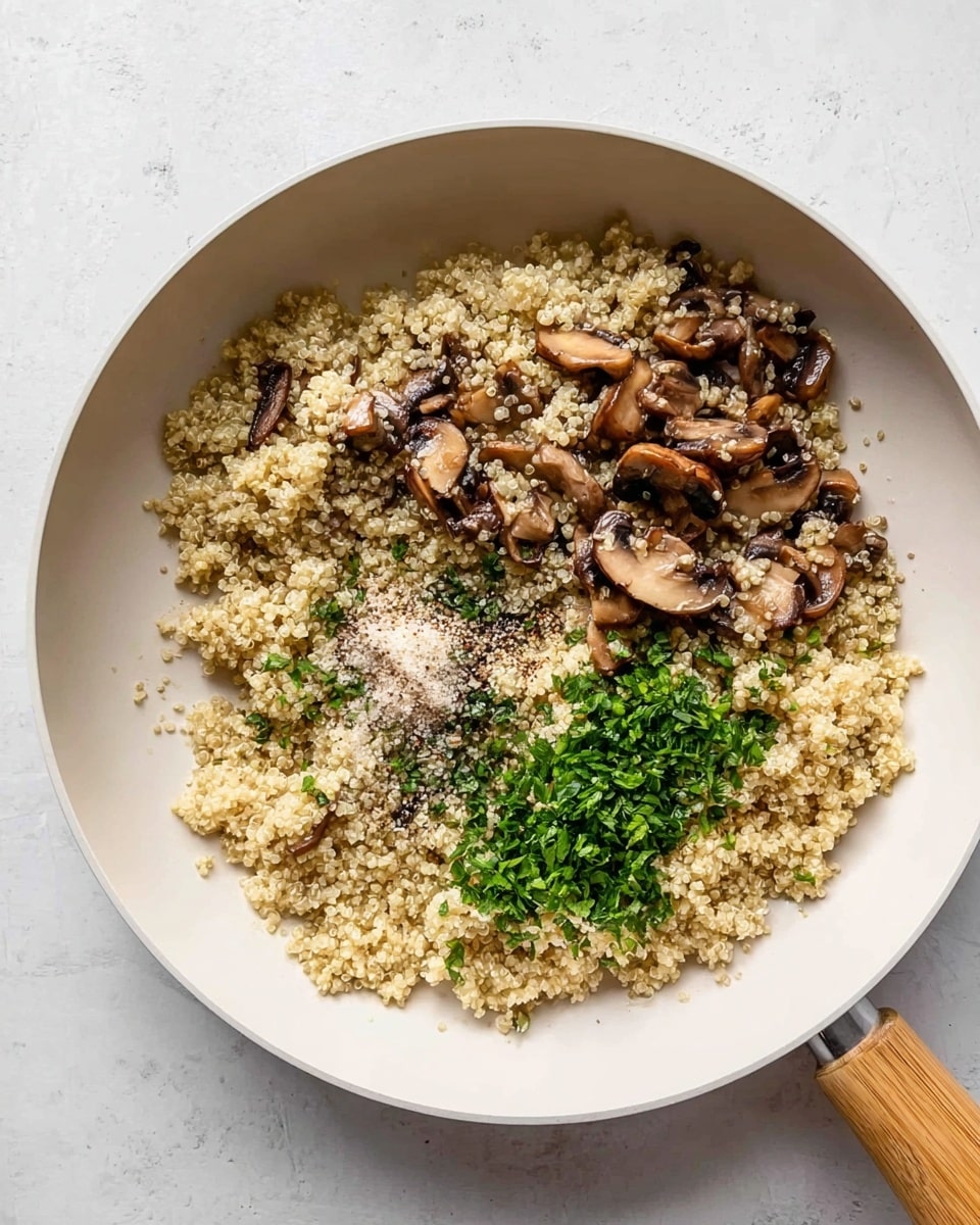 A white pan holds a mix of light beige quinoa and sliced brown mushrooms, with a small pile of finely chopped green herbs on the right side near the center and a sprinkle of salt and pepper in the middle. The quinoa looks fluffy and textured, while the mushrooms have a soft, slightly cooked appearance spread evenly throughout. The pan rests on a white marbled surface, and there is a wooden handle attached to the pan at the bottom right. Photo taken with an iphone --ar 4:5 --v 7