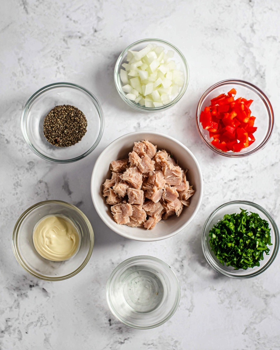 The image shows six small clear glass bowls and one white bowl on a white marbled surface. The white bowl in the center is filled with light brown chunked tuna. Starting from the top moving clockwise, the first glass bowl has bright red diced bell peppers, the next bowl contains finely chopped white onions, and the last one has green chopped herbs. Below the herbs is a small bowl with a clear liquid, possibly lemon juice. To the left is a bowl holding black pepper, and above that is a bowl with creamy mayonnaise. The setup is clean and organized, with the different ingredients spaced evenly around the tuna bowl. Photo taken with an iphone --ar 4:5 --v 7