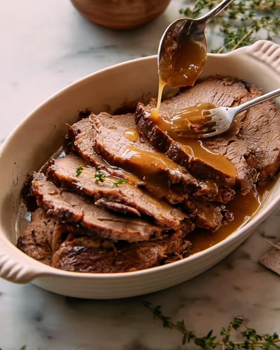 A white oval dish holds several pieces of cooked meat with a brown color and tender texture, layered unevenly inside the dish. A spoon is pouring a glossy, golden-brown sauce over the top layer of meat, adding shine and moisture. Near the dish, a woman's hand holds a fork poised to take a piece. The background features a white marbled surface with sprigs of fresh herbs nearby, adding a natural touch. Photo taken with an iphone --ar 4:5 --v 7