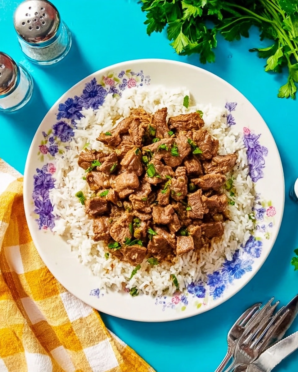 A white plate with a floral rim design holds a dish featuring a base layer of white rice spread evenly across the plate. On top, there is a generous layer of brown meat pieces, cooked to a tender texture with visible herbs sprinkled on top, adding small green spots throughout the meat. The plate sits on a bright blue surface, with a white marbled texture subtly visible beneath nearby objects. To the side, there is a yellow and white checkered cloth and two silver forks, while fresh green parsley and salt and pepper shakers are placed around, adding freshness to the scene. photo taken with an iphone --ar 4:5 --v 7