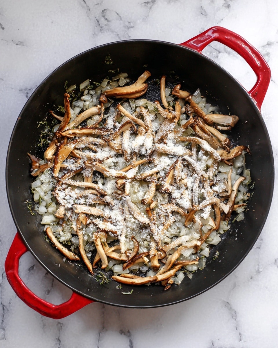Inside a black pan with red handles on a white marbled surface, there is a layer of small, chopped translucent onions and herbs cooking. Scattered on top are thin, light brown mushroom strips that have a slightly shiny texture from cooking. White powder, likely flour, is sprinkled unevenly across the mushrooms and onions, creating a contrast with the darker ingredients underneath. The pan shows some shine from oil or butter used for cooking. photo taken with an iphone --ar 4:5 --v 7