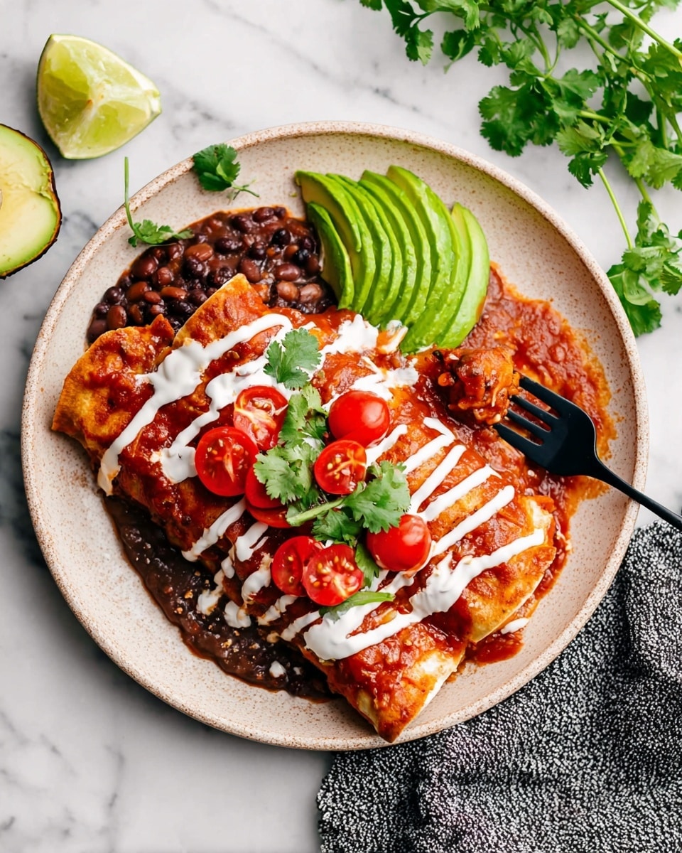 This image shows a beige plate filled with two folded enchiladas covered in red salsa and white crema in thin stripes on top. On the left side of the plate, there is a scoop of thick bean mixture with visible black beans and sauce. The center is decorated with bright green avocado slices arranged in a fan shape and fresh cilantro leaves. Scattered around the avocado and cilantro are halved cherry tomatoes adding a pop of red color. A black fork is digging into the bean mixture. The plate sits on a white marbled surface with half a lime and an avocado nearby, along with a textured gray cloth on the right side. Photo taken with an iphone --ar 4:5 --v 7