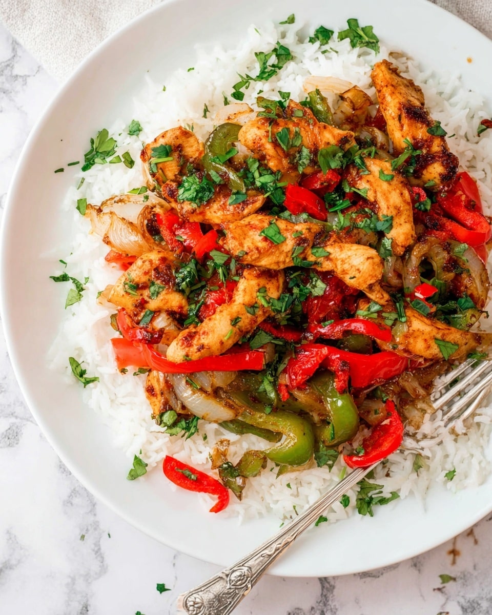 The dish is served on a white plate on a white marbled surface. The base layer consists of fluffy white rice, topped with a mix of cooked sliced red and green bell peppers, and onions that show some charred edges. Layered on top are golden-brown pieces of seasoned chicken strips, scattered with chopped fresh green herbs and small pieces of red chili for garnish, adding a fresh and colorful touch. A silver fork rests on the edge of the plate. Photo taken with an iphone --ar 4:5 --v 7