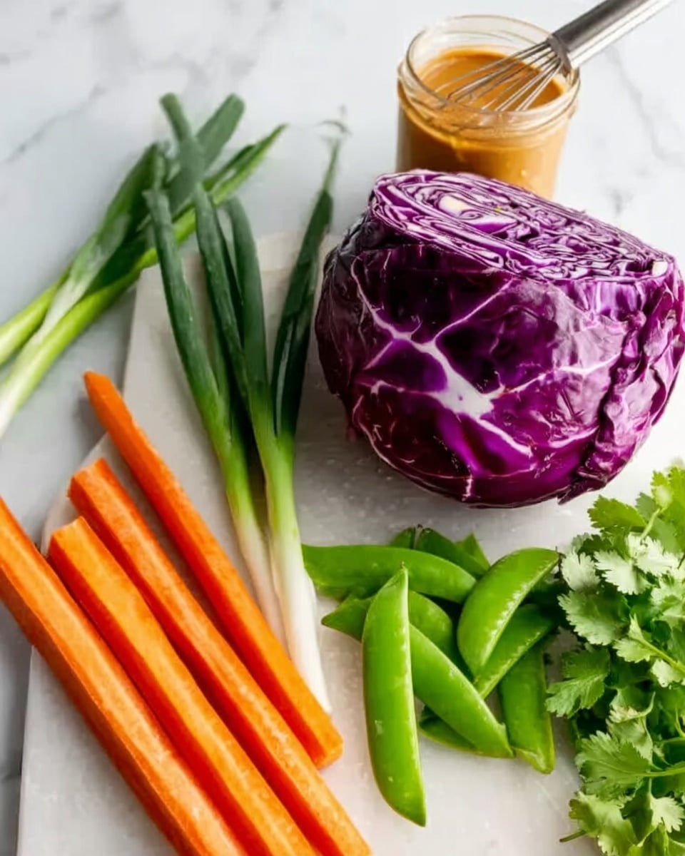 The image shows a fresh vegetable arrangement on a white marble surface. In the front, there is a half head of purple cabbage with white veins, displaying a rough texture. To the left side, there are several bright orange carrot sticks, smooth and long, lined up vertically. Behind the cabbage and carrots, there are vibrant green snow peas with a shiny surface, lying in a neat bundle. Next to the peas are long, dark green spring onions with a smooth texture, placed vertically. On the far right, there's a bunch of fresh cilantro with delicate, small green leaves. Toward the top, a jar of creamy orange sauce with a whisk inside is partially visible. The scene presents fresh vegetables with clear, bright colors on a clean white marble background. Photo taken with an iphone --ar 4:5 --v 7