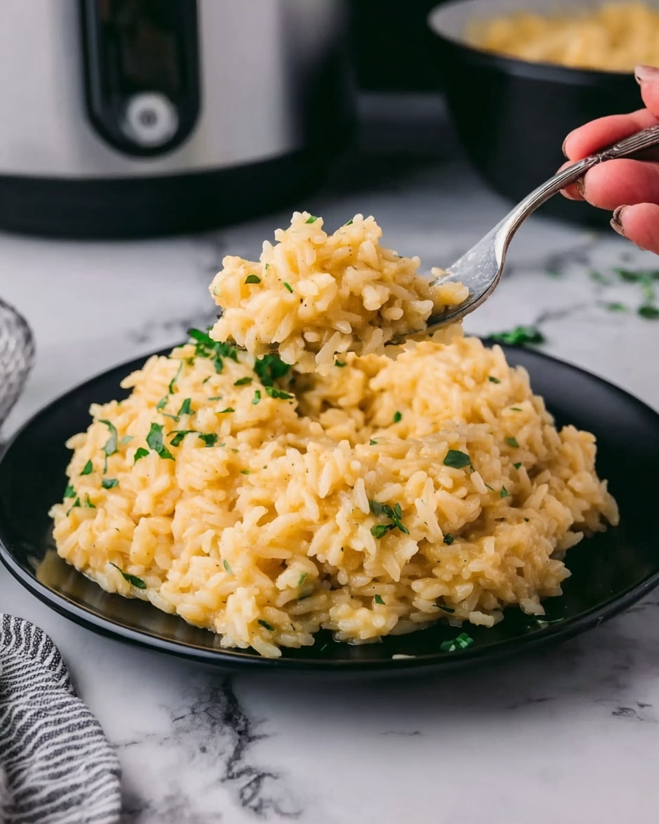 The image shows a close-up of a black plate filled with a mound of creamy yellow rice mixed with small green herbs. A woman's hand is holding a fork above the plate, lifting a scoop of the rice, which looks soft and slightly sticky. The rice grains are distinct but clumped together, and the green herbs are scattered throughout, adding small pops of color. The plate sits on a white marbled surface, and there is a striped cloth nearby along with blurred kitchen items in the background. photo taken with an iphone --ar 4:5 --v 7