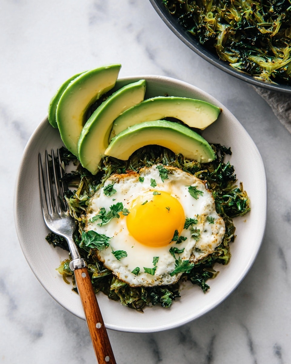 The image shows a white bowl with a round base filled with a cooked mixture of shredded greens and herbs topped with a sunny yellow egg yolk in the center. On one side of the bowl, there are three slices of fresh green avocado placed neatly. The cooked greens underneath the egg are varied shades of green and light brown, adding texture and color contrast. There is a wooden-handled fork placed diagonally inside the bowl, resting on the edge, with its metal prongs near the food. The background surface is a white marble texture. Photo taken with an iphone --ar 4:5 --v 7