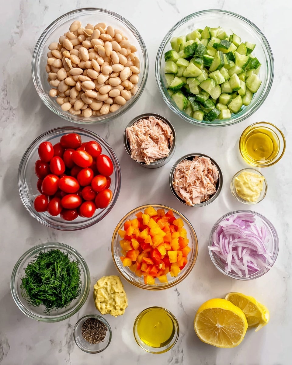 The image shows several clear glass bowls arranged neatly on a white marbled surface, each containing different fresh ingredients. There is one large bowl filled with light beige white beans, another large bowl with chunky green cucumber pieces next to it. A bowl with bright red cherry tomatoes cut in halves sits below the white beans. A small bowl with thinly sliced light purple shallots is near the center. Two open cans reveal light pink canned tuna. There are also small bowls with golden yellow olive oil, minced pale yellow garlic, creamy yellow mustard, finely chopped green parsley and dill, and bright orange diced bell peppers. Two halves of a lemon with a bright yellow and juicy inside are placed near the bottom. A small glass bowl holds coarse black pepper and salt mixed side by side. photo taken with an iphone --ar 4:5 --v 7