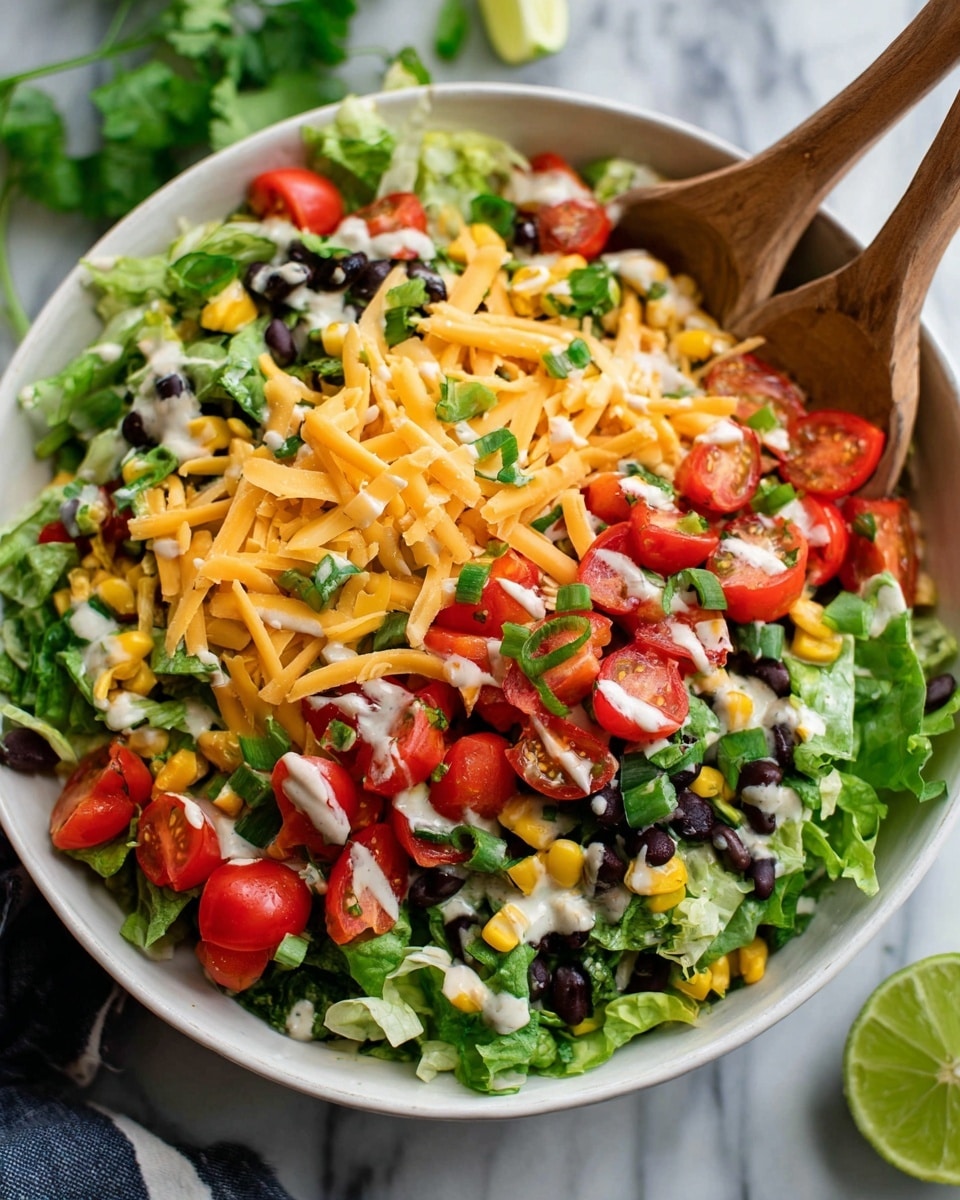 A large white bowl filled with a colorful layered salad sits on a white marbled surface. The bottom layer has green leafy lettuce with chopped red bell peppers and black beans scattered throughout. On top of that, there are bright yellow corn kernels and shredded orange cheddar cheese spread evenly. Cherry tomato halves in red sit on top, along with small bits of green onion. White creamy dressing is drizzled over the salad, and a wooden fork and spoon are placed inside the bowl, slightly lifting some of the salad. A slice of lime is visible on the right side of the bowl. photo taken with an iphone --ar 4:5 --v 7