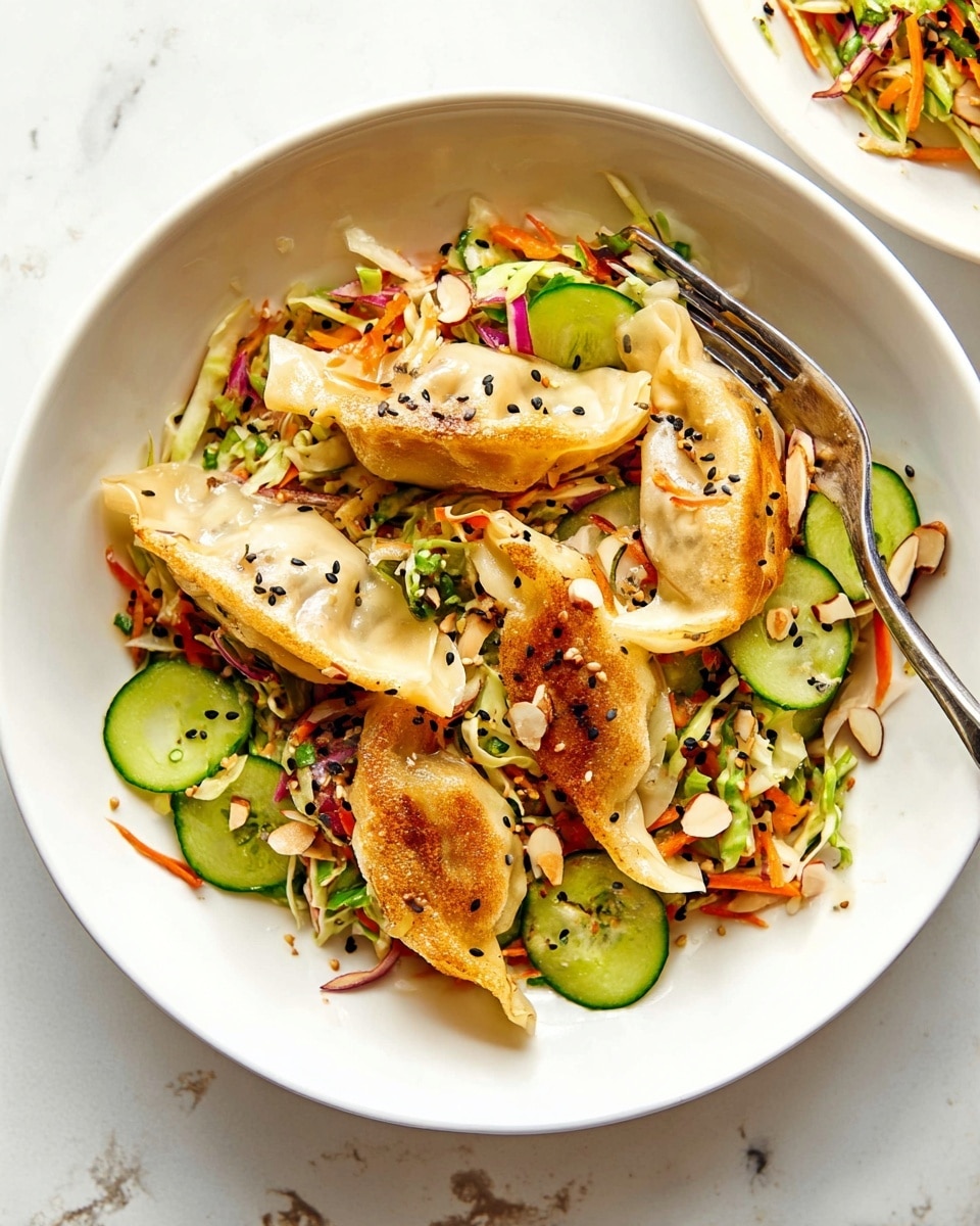 A white bowl with three light golden pan-fried dumplings sits on a white marbled surface. Underneath and around the dumplings is a colorful coleslaw made of shredded green and orange cabbage and carrots. Large pieces of fresh green cucumber slices with black sesame seeds dot the salad. Thin slices of red onion and almond flakes are mixed evenly throughout, with tiny specks of green herbs scattered on top. A silver fork rests inside the bowl, and some sesame seeds and herbs are lightly sprinkled on the marbled surface nearby. photo taken with an iphone --ar 4:5 --v 7