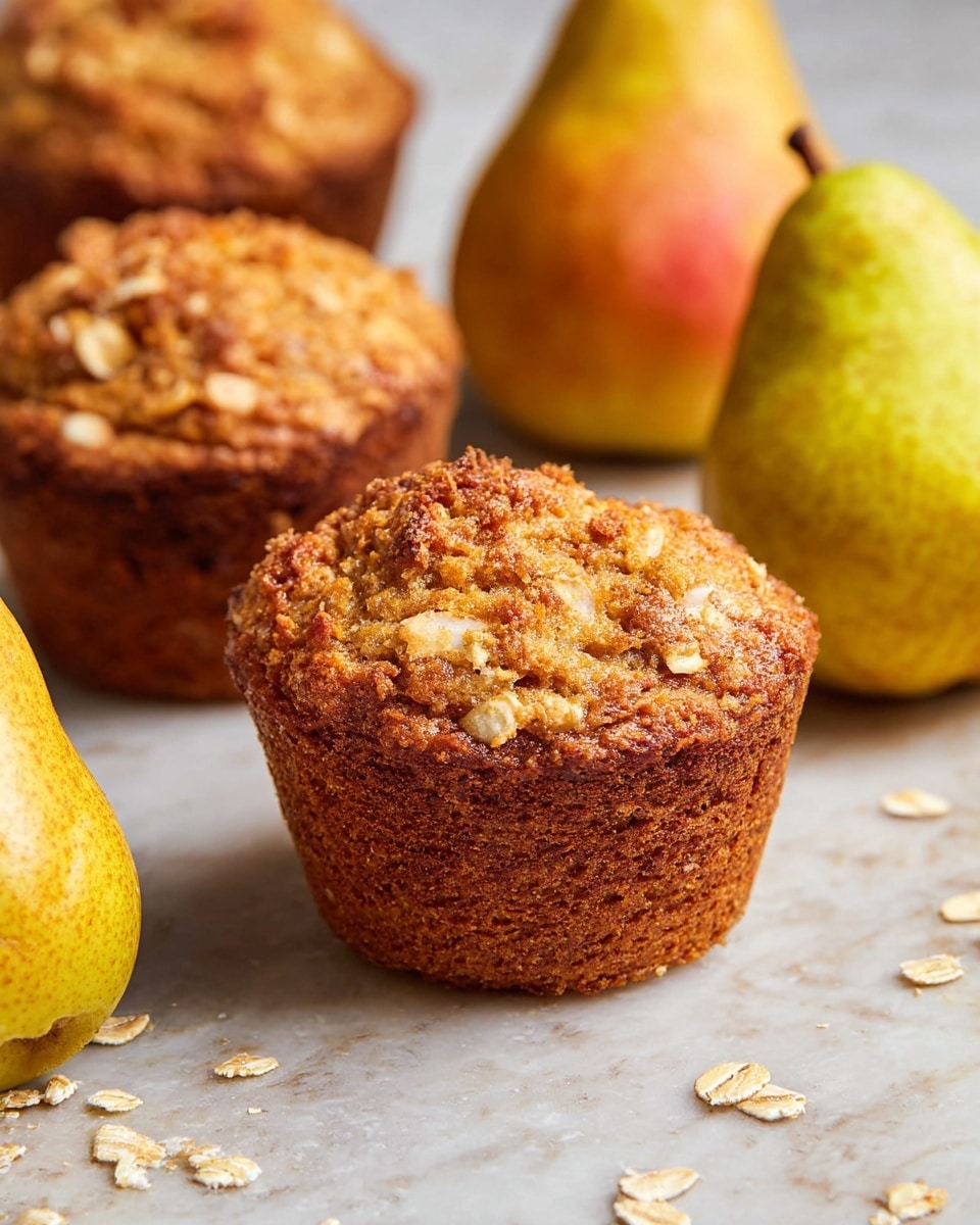 The image shows two golden brown muffins with a rough texture on top, sprinkled with oat flakes, sitting on a white marbled surface. Each muffin is thick and slightly rounded with visible crumbly pieces on the outer edge. Around the muffins, there are three whole pears, yellow-green with red patches, scattered naturally. Some oatmeal flakes are also spread on the surface near the muffins, adding a rustic touch. The overall lighting is soft and natural, emphasizing the warm tones of the muffins and pears. photo taken with an iphone --ar 4:5 --v 7