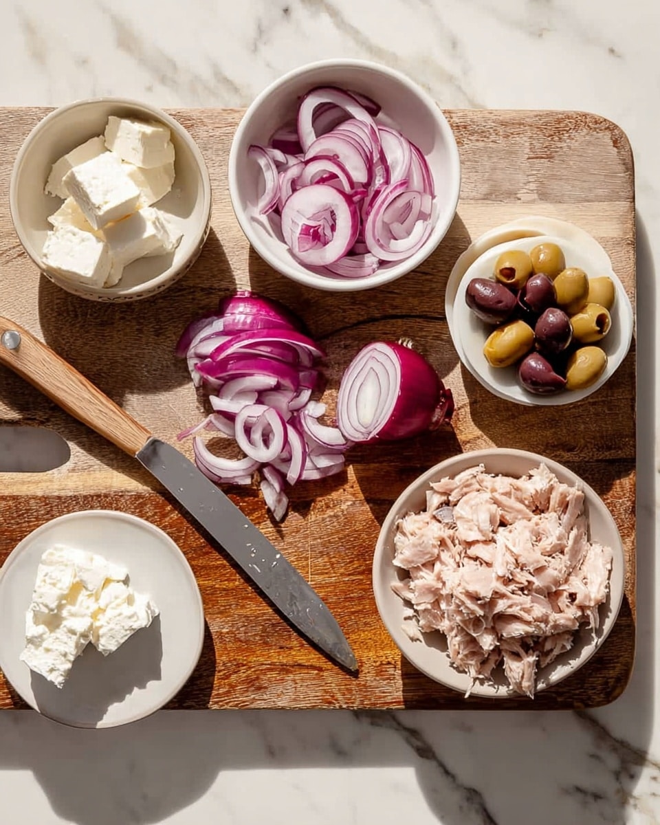 A wooden cutting board sits on a white marbled surface with several small white bowls and a white plate arranged on top. Sliced red onion pieces are in a white bowl at the top center, with half a red onion and a knife placed beside it on the board showing more slices. To the right, there is a bowl filled with light pink shredded tuna and olives both whole and sliced spread nearby. On the left side of the board, a white plate holds soft white cheese, and a small scoop of solid white cheese lies directly on the board above it. The scene is lit with natural light, creating soft shadows. Photo taken with an iphone --ar 4:5 --v 7