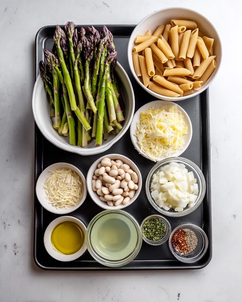A black baking tray sits on a white marbled surface holding nine small white bowls arranged neatly. The top left bowl contains green asparagus spears with purple tips, slightly piled. To its right, a white bowl is filled with tan-colored penne pasta standing upright and filling the bowl. Below the asparagus is a white bowl filled with small white beans, densely packed. Next to it, a bowl contains large white chopped onion pieces. A tiny bowl with lemon zest sits near the top right corner of the tray. At the bottom, three smaller bowls hold golden olive oil, grated garlic, and white grated cheese respectively. There is also a clear glass filled with light greenish liquid and a small bowl with a mix of spices including red pepper flakes and green herbs. The whole setup is simple, colorful, and clean, on a white marbled surface photo taken with an iphone --ar 4:5 --v 7