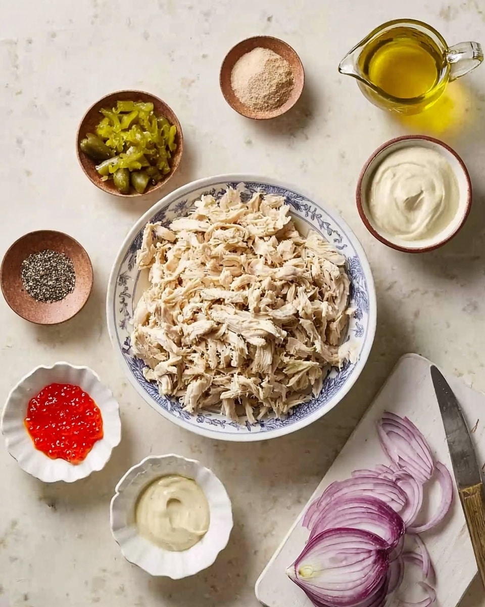 The image shows a white bowl with blue details filled with a large amount of shredded cooked chicken in beige tones, placed on a white marbled surface. Around the bowl, there are six small dishes arranged in a loose circle: a small brown bowl with a mix of white salt and black pepper; a white scalloped dish with chopped light green pickles; a white scalloped dish with bright red caviar; a small white bowl with a light tan powder; a small brown bowl containing thick white yogurt; a small clear glass pitcher with golden yellow oil; and a small white bowl with creamy beige mayonnaise. To the right, a white cutting board holds a halved red onion and a small pile of finely chopped red onion, with a knife resting on the board. A woman's hand is not visible in this image. Photo taken with an iphone --ar 4:5 --v 7