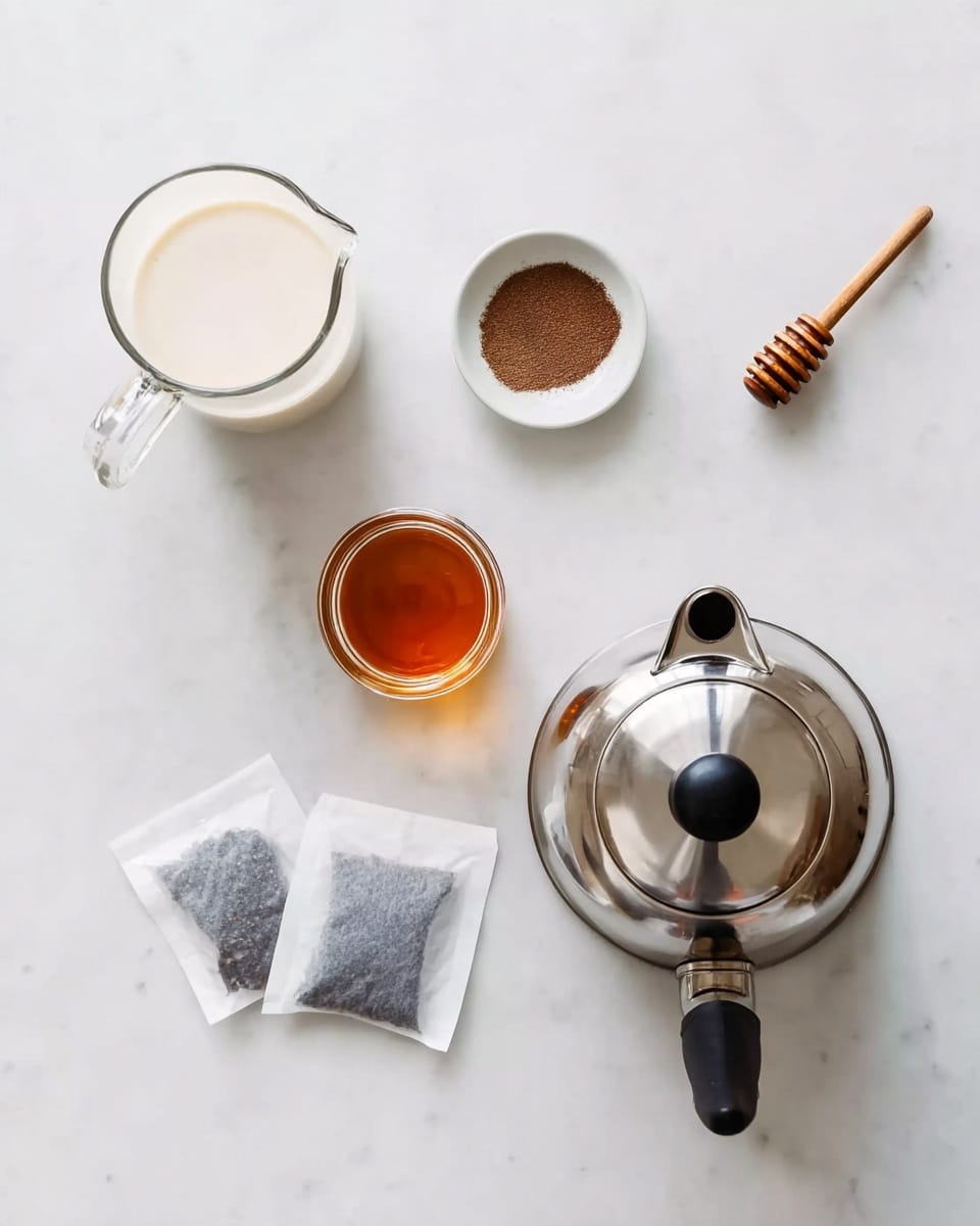 The image shows a top view of various tea-making items arranged neatly on a white marbled surface. On the left, there is a glass jug filled with milk, shaped with a spout and handle. Next to it is a small white round dish with a little brown powder inside, likely vanilla. In the center, there is a small clear jar of honey with an orange-brown wooden honey dipper placed on top. Below that are two white tea bags with visible black tea leaves through their semi-transparent paper. On the right, there is a shiny silver kettle with a black handle, seen from the top with its lid open, showing the inside. The whole setup is clean and simple. Photo taken with an iphone --ar 4:5 --v 7
