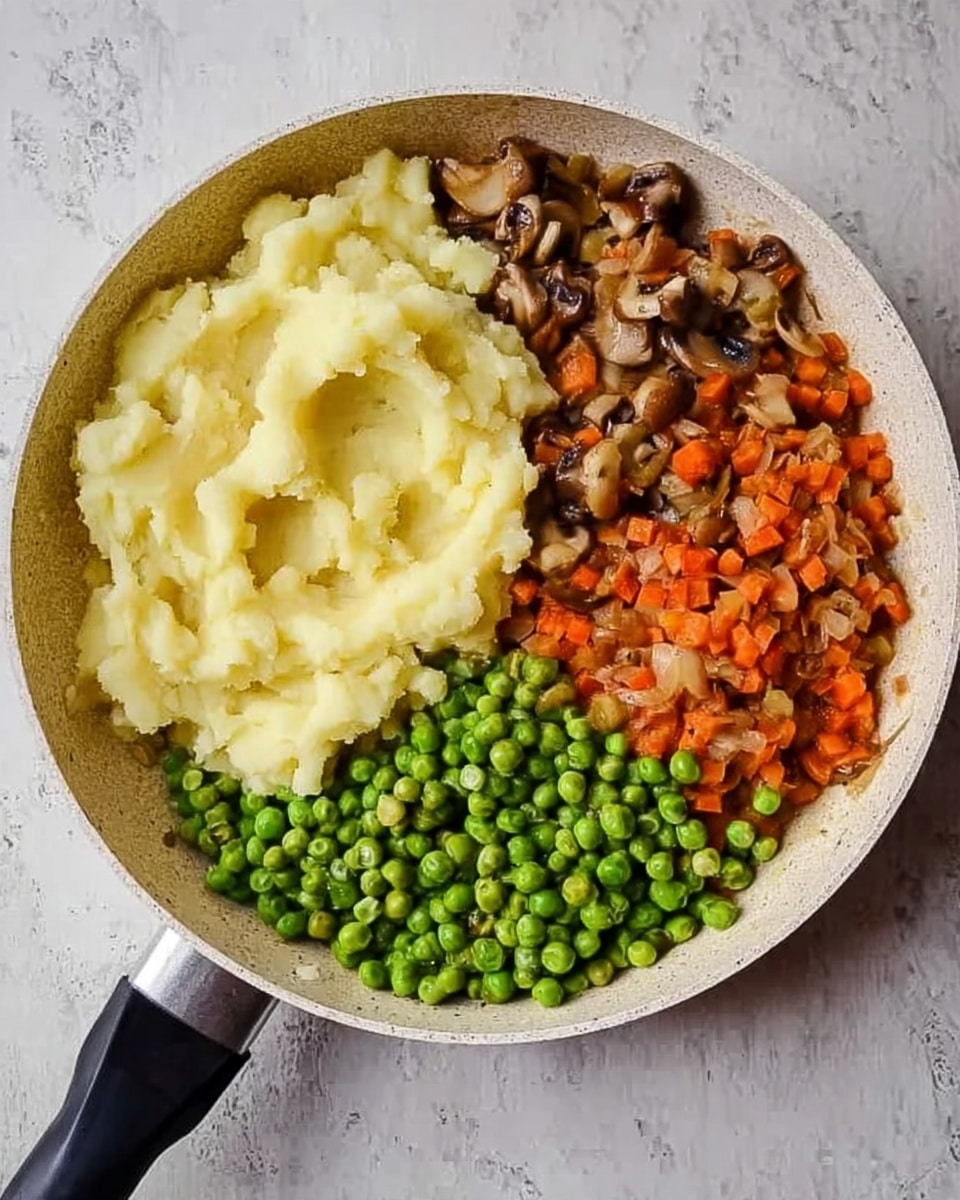 A close top-down view of a white frying pan filled with three separate groups of food layers on a white marbled surface: the top layer is a large portion of smooth, pale yellow mashed potatoes, the right section holds a heap of small, round, bright green peas, and the left side contains a mix of finely chopped orange carrots and brown mushrooms. The pan's black handle extends towards the bottom left corner, creating a simple and homey presentation. photo taken with an iphone --ar 4:5 --v 7