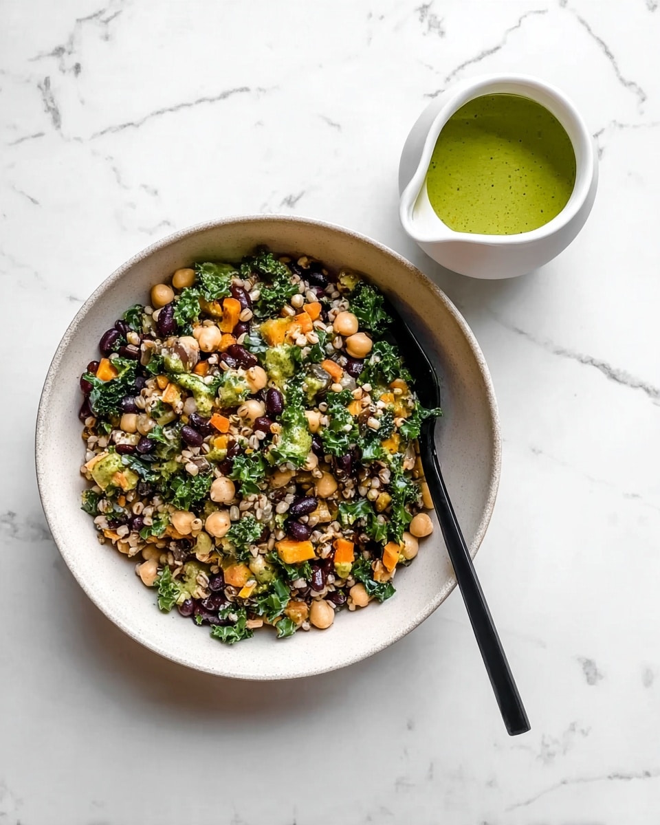 A bowl with a mix of grains, black beans, chickpeas, chopped green kale, and small orange carrot pieces, all combined to create a colorful salad with a textured and fresh look. A black spoon is placed inside the white bowl on the right side. Next to the bowl, there is a small white sauce pitcher filled with bright green dressing. The background is a white marbled surface. photo taken with an iphone --ar 4:5 --v 7